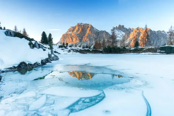 View of the frozen lake of Limides with the reflection of the snowy peak of Lagazuoi in the ice cracks, Dolomites, Passo Falzarego, Veneto, Belluno province, Italy, Europe