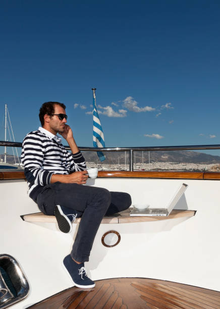 istock Businessman reading emails and having coffee on the yacht. 168259053