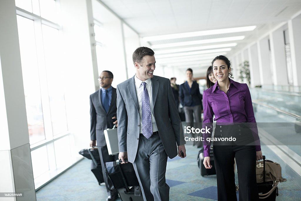 Lotnisko z działalności zespołu krótkiego, pociągając bagażu i uśmiechania się, - Zbiór zdjęć royalty-free (Lotnisko)