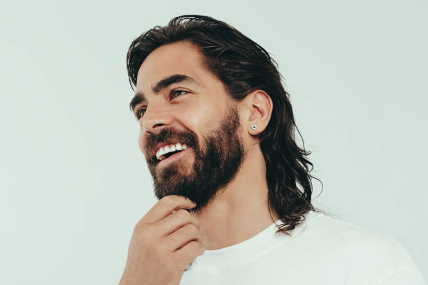 istock Man with a beard smiling happily in a studio, showing off his perfect look 1682596117