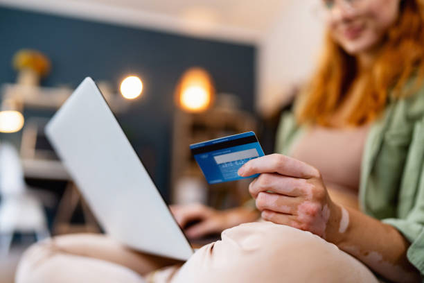 istock Unrecognizable woman with vitiligo, using laptop while online shopping from home 1682600731