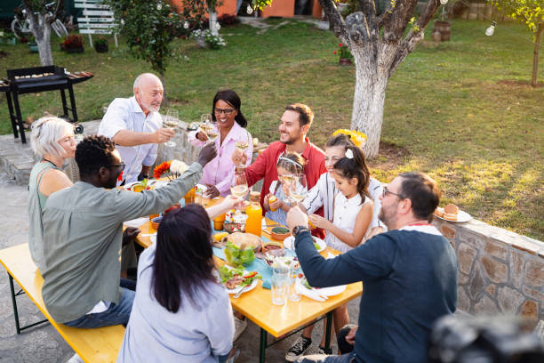 istock Multiracial and multi-generation families toasting during an family lunch 1682603919