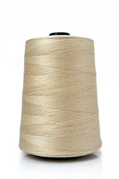 Photo of A big spool of gold sewing thread