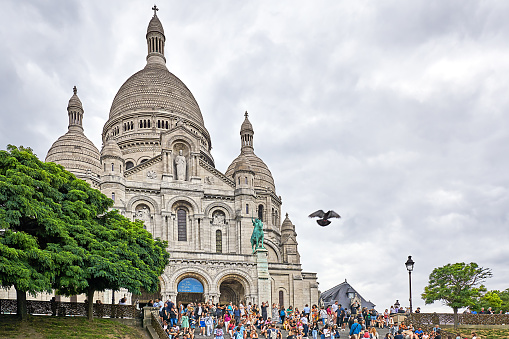 Paris, France - July 13, 2023: People on the steps of the Sacre Coeur Basilica in the Montmartre district.