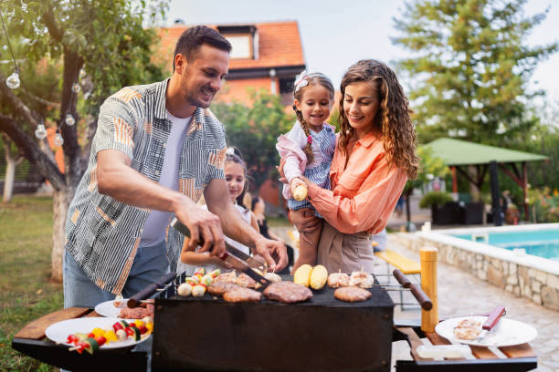 kaukasische eltern mit töchtern, die grillen, für einen familienbrunch - barbecue chicken fotos stock-fotos und bilder