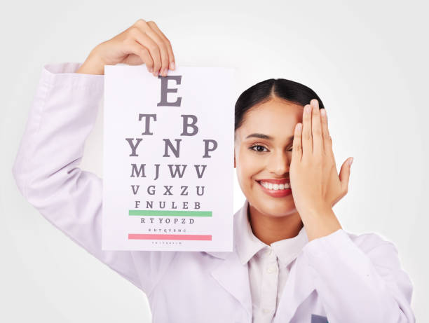 portrait, smile and eye test with a woman optician in studio on a gray background for vision or eyesight. face, medical and a happy young doctor in a clinic or optometry office for a visual exam - telephone doctor medical exam healthcare and medicine imagens e fotografias de stock