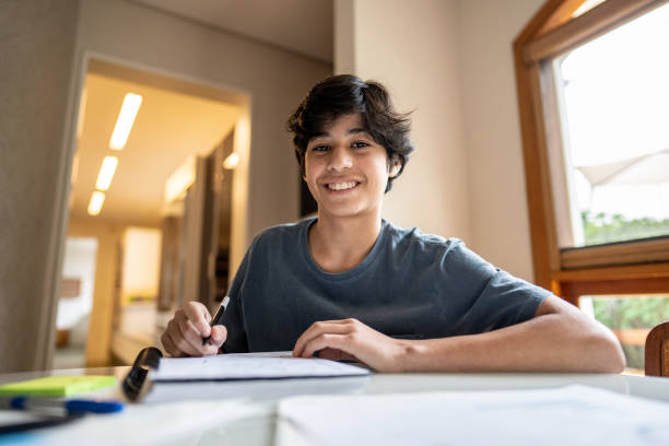 Portrait of a teenager boy studying at home Portrait of a teenager boy studying at home happy young teens stock pictures, royalty-free photos & images