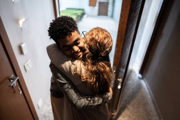 istock Aunt greeting nephew arriving at home 1682621586