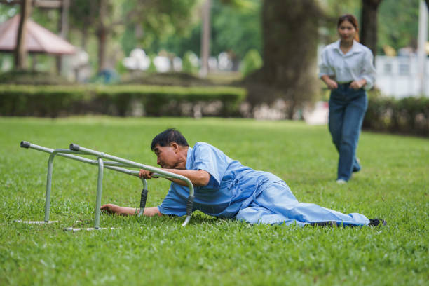 An elderly male patient uses it to help him walk and falls. An elderly man falls while learning to walk with a walker. A young woman and daughter run in to help support him. A patient falls.