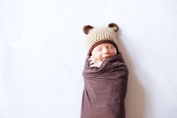 istock Sleeping Newborn Swaddled and Wearing a Bear Hat 168262517