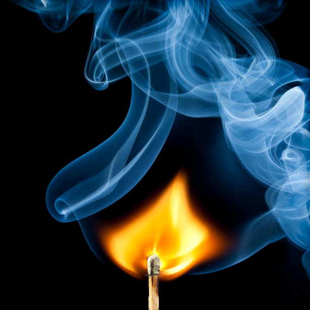 Burnt match with trailing smoke after being blown out on a black background