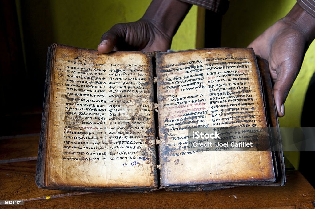 Christian book in Lake Tana, Ethiopia An Ethiopian man at a Lake Tana monastery, in Ethiopia, holds up a religious book dating back several centuries, probably to the 13th or 14th century. It is written in the ancient Semitic language of Ge'ez. The language is no longer spoken, except in some church liturgies. The text is handwritten and the pages made of animal skin. Ethiopia Stock Photo