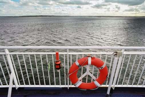 Lifebuoy aboard  a passenger ship with view of the North Sea. Large depth of focus.