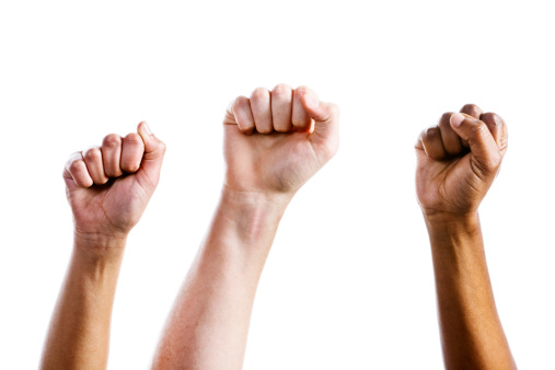 Three clenched fists are raised in defiance or triumph. Isolated on white. 