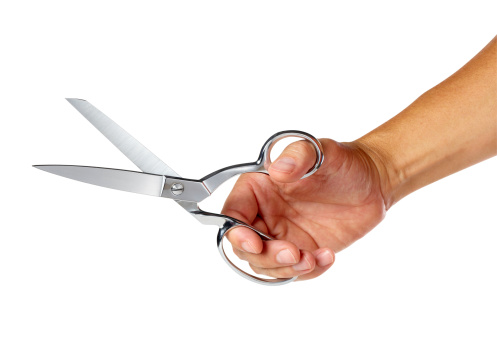 Hand holding pair of scissors, Isolated on white background, larger files include path.  Color corrected, exported 16 bit depth, professionally retouched and saved for maximum image quality.