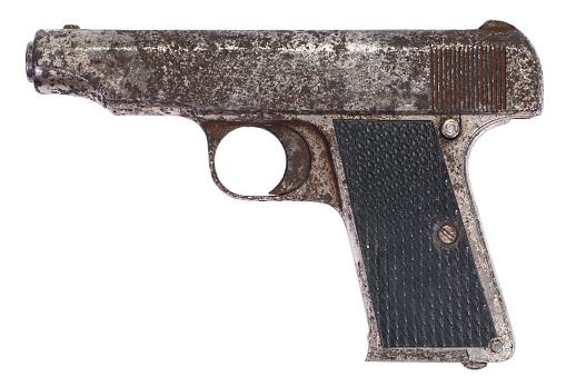 Old vintage rusty pistol isolated on white