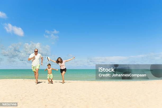 Feliz Familia De Vacaciones En La Playa Foto de stock y más banco de imágenes de Adulto - Adulto, Aire libre, Alegre
