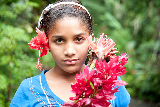 An 8 year old Costa Rican Native girl with colorful flowers and striking eyes and copy-space.