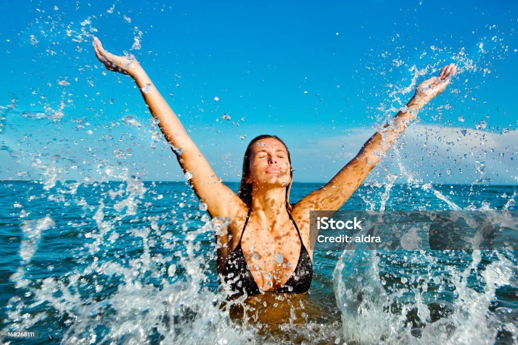 Splash Beautiful mature woman splashing in the ocean Activity Stock Photo