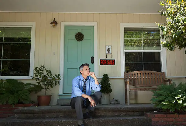 Photo of Man in suit outside home being foreclosed