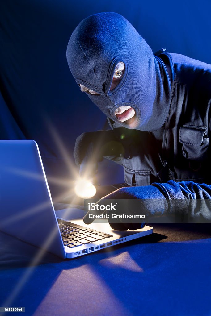 Ladrão roubando dados com lanterna DVD de laptop - Foto de stock de Arrombador royalty-free