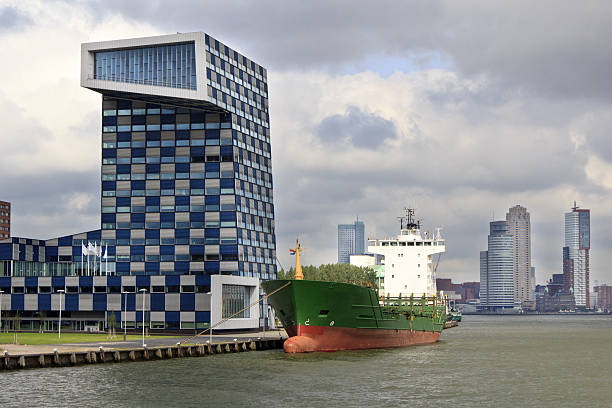 A shop moored outside the Shipping and Transport College in the Lloydkwartier of  Rotterdam, Netherlands. In the background the skyscrapers of the Kop van Zuid.