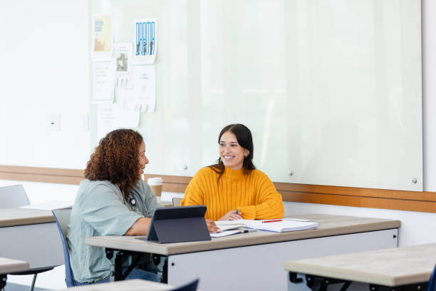 istock Female teacher uses digital tablet during tutoring session with student 1682693992