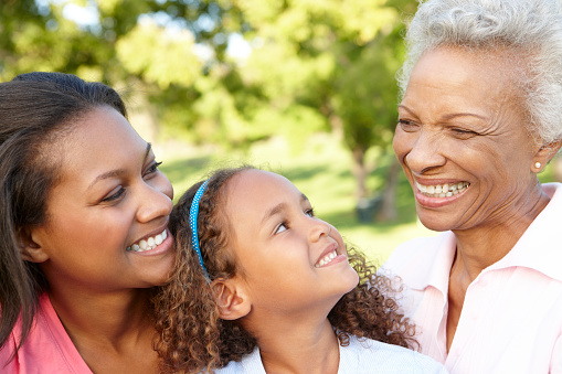 African American Grandmother, Mother And Daughter Relaxing In Park