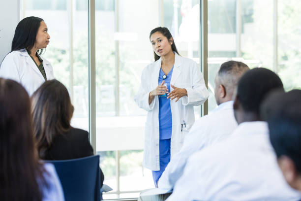 istock Two female doctors lead seminar for unrecognizable colleagues 1682699561