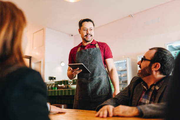 istock Waiter taking customers' order at restaurant 1682701809