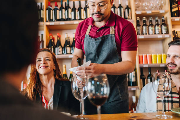 istock Waiter serving wine to customers at restaurant 1682701831