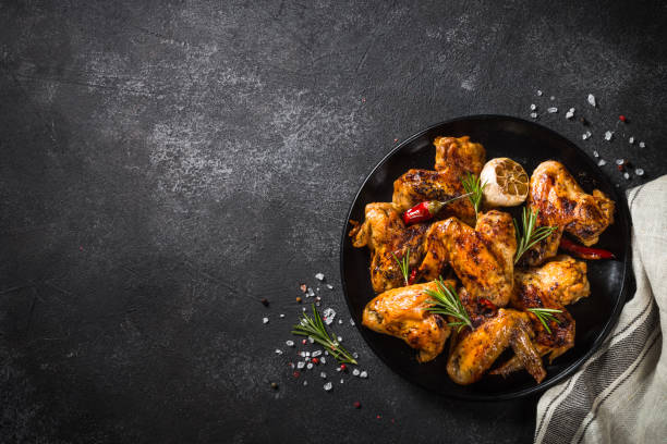 istock Grilled chicken wings with spices at black table. 1682708801