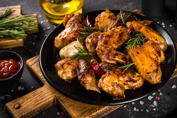 istock Grilled chicken wings with spices in black plate. 1682708946