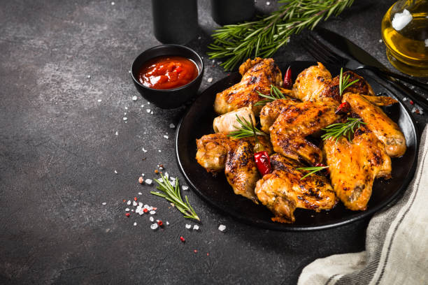 istock Grilled chicken wings with spices in black plate. 1682710099