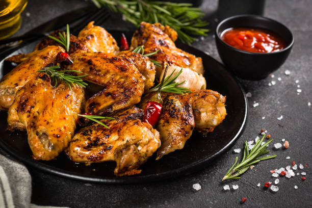 istock Grilled chicken wings with spices in black plate. 1682710103