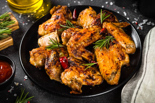 istock Grilled chicken wings with spices in black plate. 1682710108