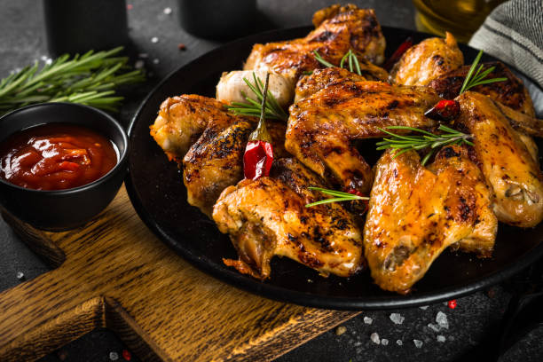 istock Grilled chicken wings with spices in black plate. 1682710114
