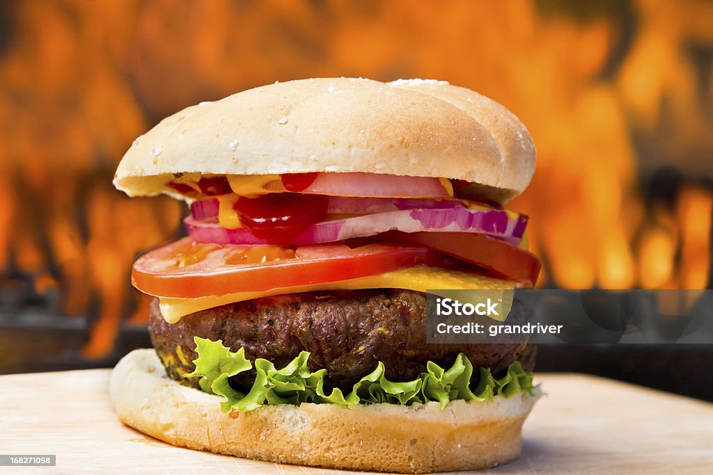 Grande Cheeseburger con graziosi fiamme - Foto stock royalty-free di Alimento di base