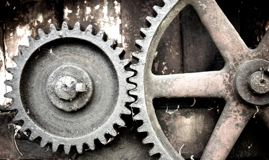 Large cogs on redundant farm machinery