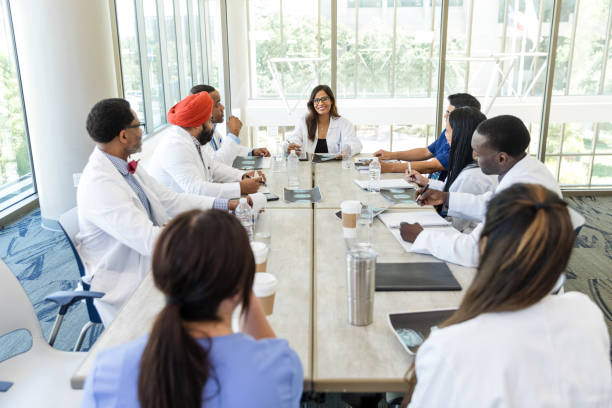 istock High angle view diverse hospital staff sitting around conference table 1682711281