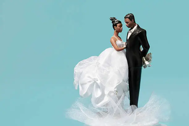 African American bride and groom wedding cake topper on blue background