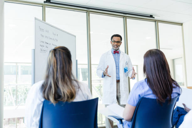 istock Male doctor gestures while make point in meeting with staff 1682722826
