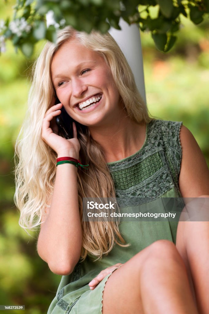 Młoda dziewczyna komunikuje się z Telefon komórkowy Telefon komórkowy - Zbiór zdjęć royalty-free (Blond włosy)