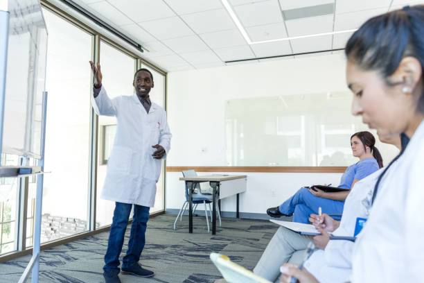 gestos de profissionais de saúde do sexo masculino para o quadro branco durante a apresentação - male black medical student mature student - fotografias e filmes do acervo