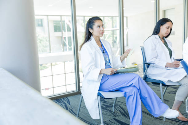 istock Female medical professionals take notes during seminar 1682727197