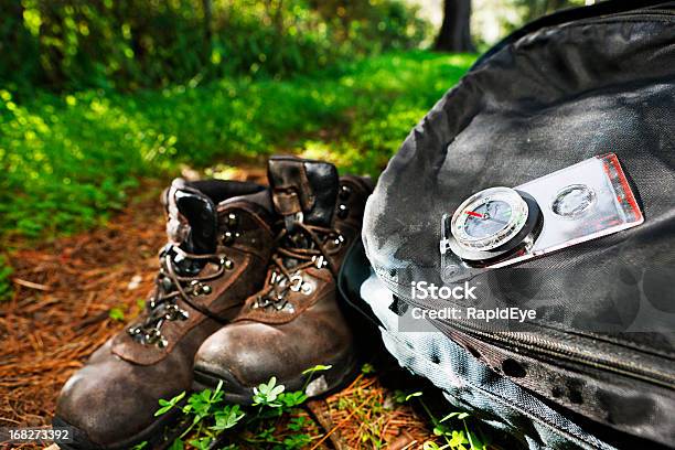 Photo libre de droit de Randonnée À Thème Bottes Sac À Dos Et Boussole Sur Radieux Sentier Forestier banque d'images et plus d'images libres de droit de Camping