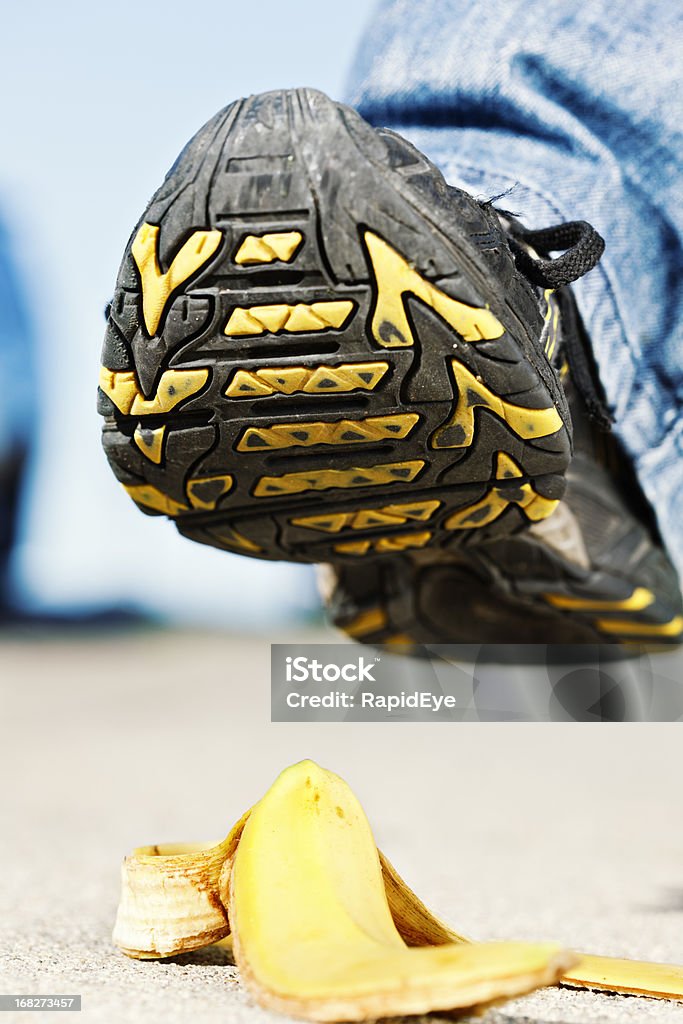 Hombre de pie enfoques disminuyó piel de plátano, podría ser doloroso. - Foto de stock de Accidentes y desastres libre de derechos