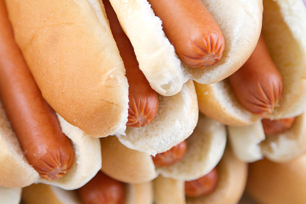Vienna, Austria, August 2022. Close-up shot of mouth-watering sausage and mustard sandwiches, a local specialty. Against the blurry background of french fries.