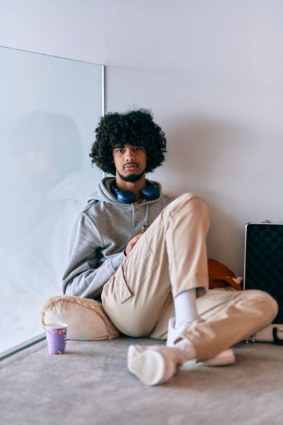 istock African-American entrepreneur taking a relaxing break from work, sitting on the floor while using wireless headphones and a smartphone for some digital entertainment. 1682749252