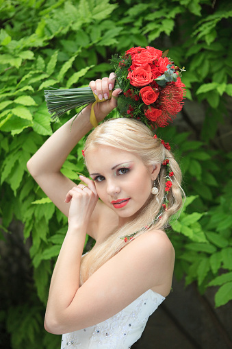 Beautiful blonde in a wedding dress. A young woman with a bouquet.